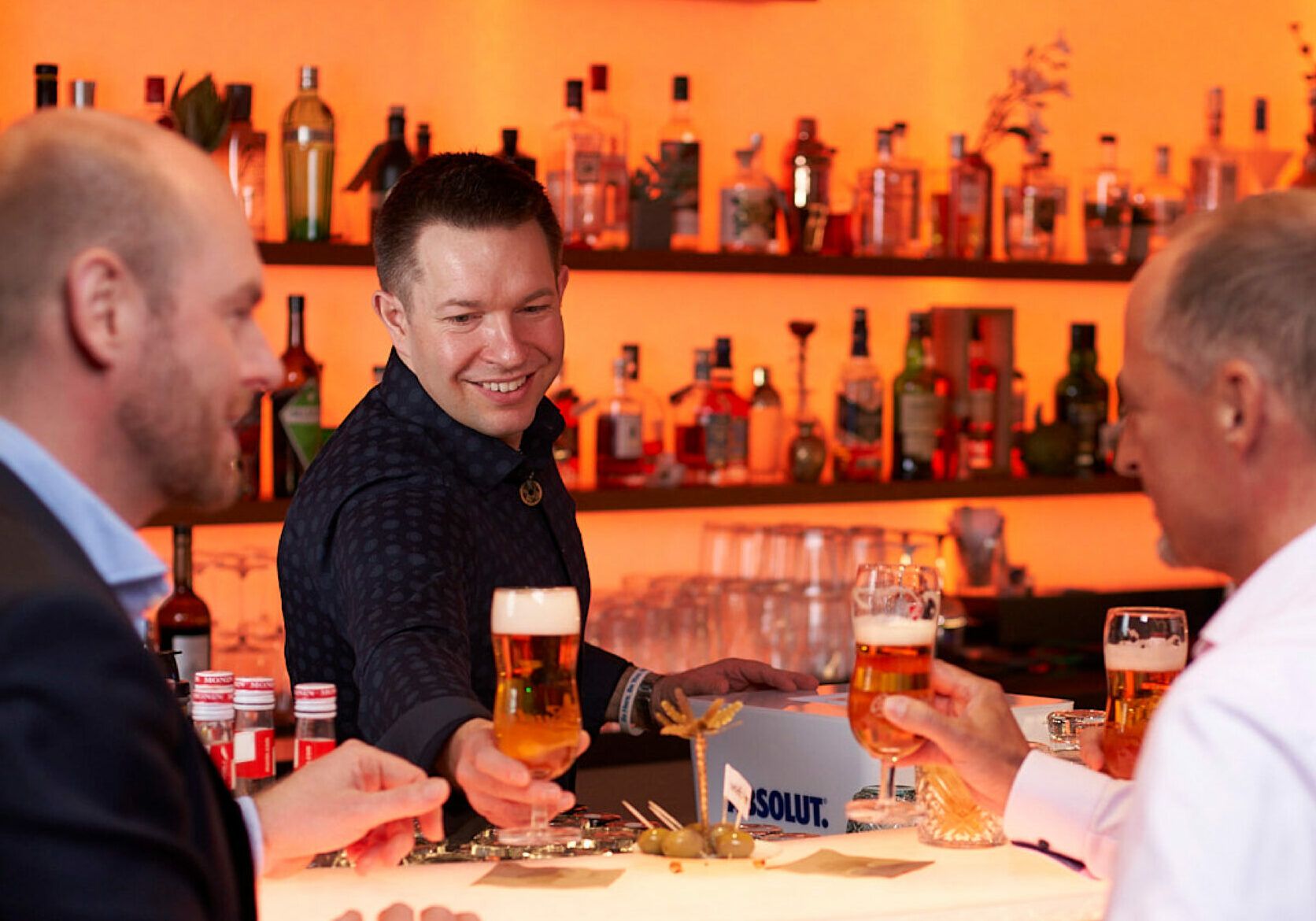 Barmann gibt zwei Männer Bier in der Spielbank Leipzig