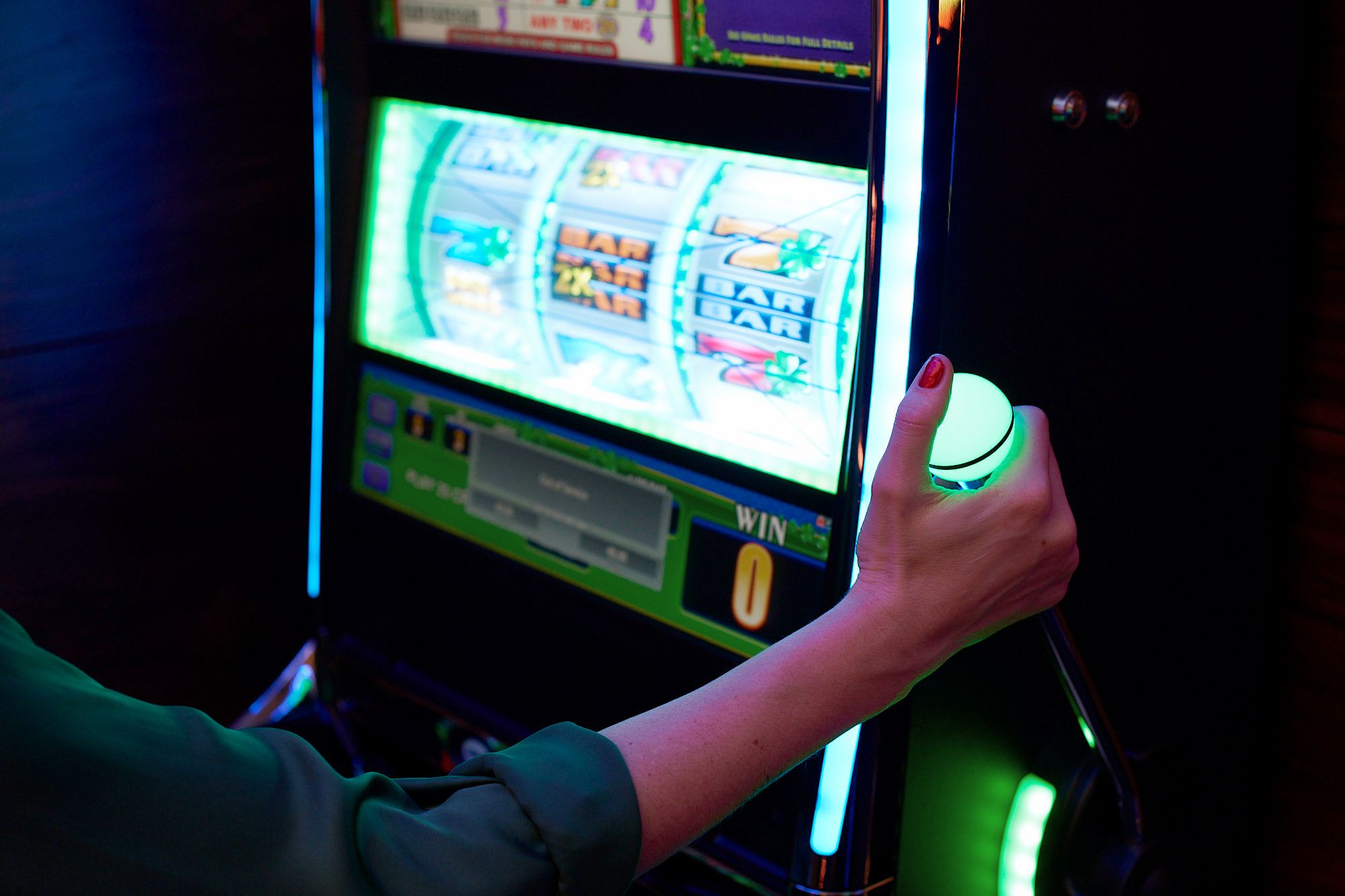 Eine Frau betätigt den grün leuchtenden Hebel der Slot Machine