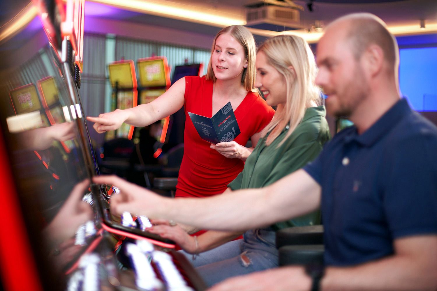 Erster Besuche bei den Spielbanken Sachsen: Mann und Frau bekommen eine Einführung in die Spielautomaten.