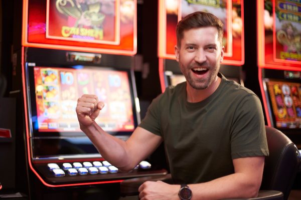 Ein Mann freut sich über Gewinn am Spielautomat in der Spielbank Leipzig